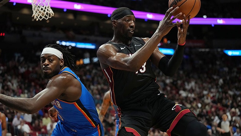 Jan 10, 2024; Miami, Florida, USA; Miami Heat center Bam Adebayo (13) grabs a loose ball as Oklahoma City Thunder guard Luguentz Dort (5) defends during the first half at Kaseya Center. Mandatory Credit: Jim Rassol-USA TODAY Sports