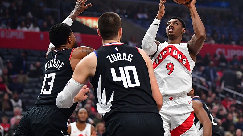 Jan 10, 2024; Los Angeles, California, USA; Toronto Raptors guard RJ Barrett (9) shoots against Los Angeles Clippers forward Paul George (13) and center Ivica Zubac (40) during the first half at Crypto.com Arena. Mandatory Credit: Gary A. Vasquez-USA TODAY Sports