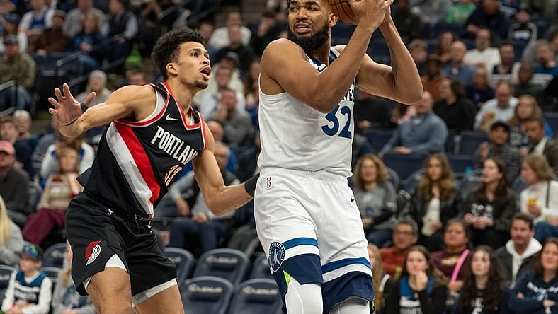 Jan 12, 2024; Minneapolis, Minnesota, USA; Minnesota Timberwolves center Karl-Anthony Towns (32) looks for a teammate defended by Portland Trail Blazers forward Toumani Camara (33) in the first quarter at Target Center. Mandatory Credit: Matt Blewett-USA TODAY Sports