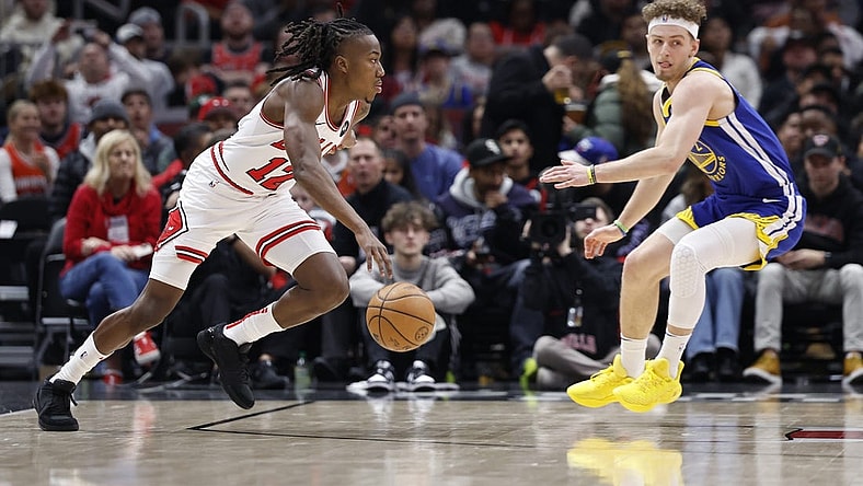 Jan 12, 2024; Chicago, Illinois, USA; Chicago Bulls guard Ayo Dosunmu (12) drives against Golden State Warriors guard Brandin Podziemski (2) during the first half at United Center. Mandatory Credit: Kamil Krzaczynski-USA TODAY Sports