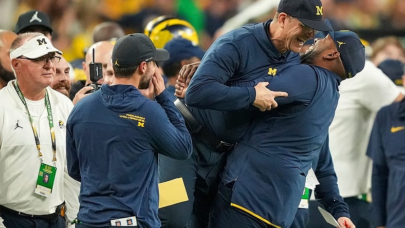 Michigan head coach Jim Harbaugh is lifted off the ground by offensive coordinator Sherrone Moore after Michigan won the College Football Playoff national championship game against Washington at NRG Stadium in Houston on Monday, Jan. 8, 2024.