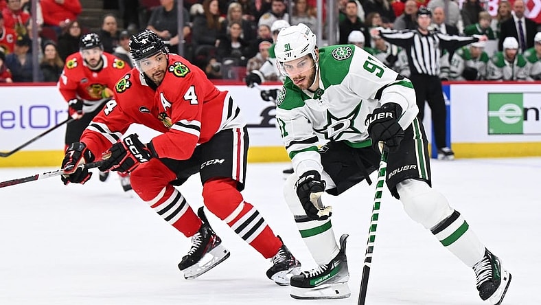 Jan 13, 2024; Chicago, Illinois, USA;  Dallas Stars forward Tyler Seguin (91) controls the puck while being defended by Chicago Blackhawks defenseman Seth Jones (4) in the second period at United Center. Mandatory Credit: Jamie Sabau-USA TODAY Sports