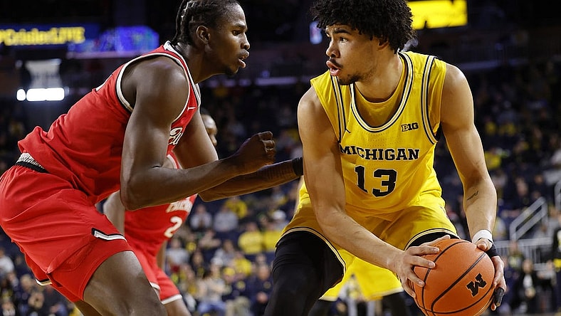 Jan 15, 2024; Ann Arbor, Michigan, USA; Michigan Wolverines forward Olivier Nkamhoua (13) dribbles as Ohio State Buckeyes center Felix Okpara (34) defends in the first half at Crisler Center. Mandatory Credit: Rick Osentoski-USA TODAY Sports