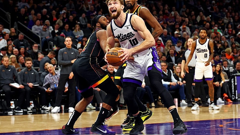 Jan 16, 2024; Phoenix, Arizona, USA; Sacramento Kings forward Domantas Sabonis (10) drives to the basket against Phoenix Suns forward Josh Okogie (2) and forward Nassir Little (25) during the fourth quarter at Footprint Center. Mandatory Credit: Mark J. Rebilas-USA TODAY Sports