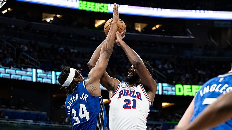 Jan 19, 2024; Orlando, Florida, USA; Philadelphia 76ers center Joel Embiid (21) shoots the ball over Orlando Magic center Wendell Carter Jr. (34) in the second quarter at KIA Center. Mandatory Credit: Jeremy Reper-USA TODAY Sports