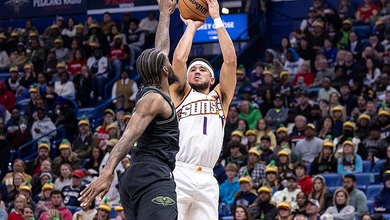 Jan 19, 2024; New Orleans, Louisiana, USA;  Phoenix Suns guard Devin Booker (1) shoots against New Orleans Pelicans forward Naji Marshall (8) during the first half at Smoothie King Center. Mandatory Credit: Stephen Lew-USA TODAY Sports