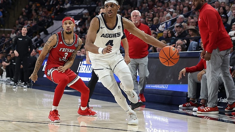 Jan 20, 2024; Logan, Utah, USA; Utah State Aggies guard Ian Martinez (4) drives past Fresno State Bulldogs guard Isaiah Hill (3) during the first half at Dee Glen Smith Spectrum. Mandatory Credit: Rob Gray-USA TODAY Sports