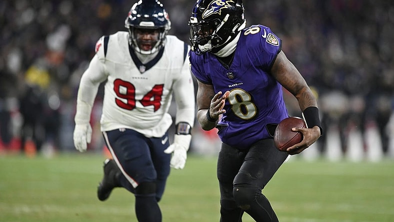 Jan 20, 2024; Baltimore, MD, USA; Baltimore Ravens quarterback Lamar Jackson (8) runs the ball to score a touchdown against Houston Texans defensive tackle Khalil Davis (94) during the fourth quarter of a 2024 AFC divisional round game at M&T Bank Stadium. Mandatory Credit: Tommy Gilligan-USA TODAY Sports