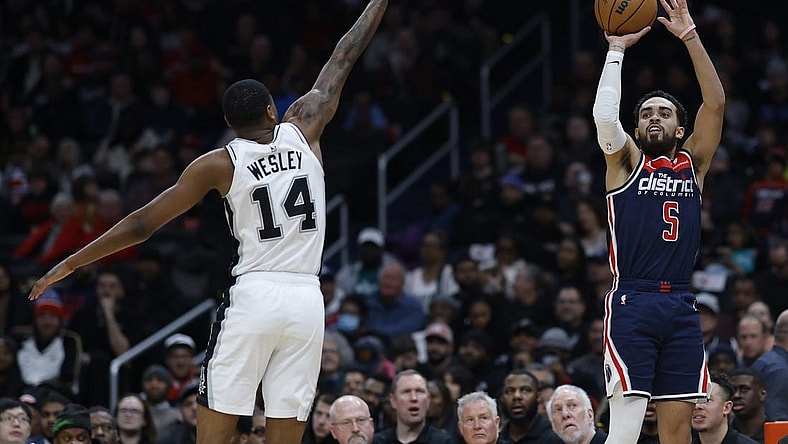Jan 20, 2024; Washington, District of Columbia, USA; Washington Wizards guard Tyus Jones (5) shoots the ball as San Antonio Spurs guard Blake Wesley (14) defends in the second quarter at Capital One Arena. Mandatory Credit: Geoff Burke-USA TODAY Sports