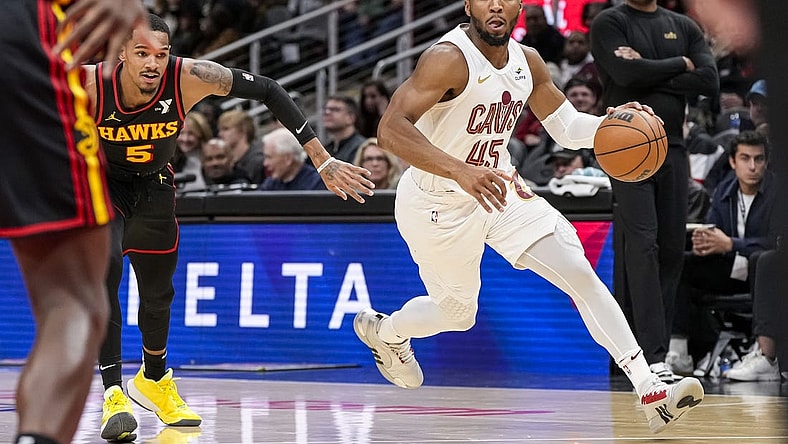 Jan 20, 2024; Atlanta, Georgia, USA; Cleveland Cavaliers guard Donovan Mitchell (45) dribbles past Atlanta Hawks guard Dejounte Murray (5) during the first half at State Farm Arena. Mandatory Credit: Dale Zanine-USA TODAY Sports