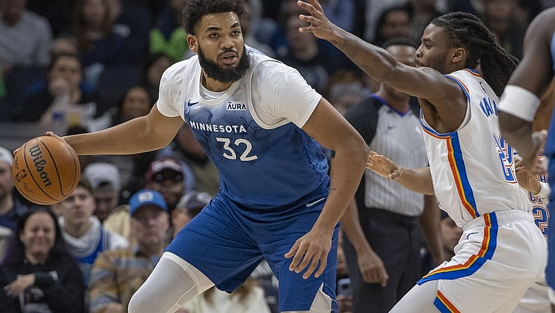 Jan 20, 2024; Minneapolis, Minnesota, USA; Minnesota Timberwolves center Karl-Anthony Towns (32) dribbles the ball and looks to pass Oklahoma City Thunder guard Cason Wallace (22) plays defense in the first half at Target Center. Mandatory Credit: Jesse Johnson-USA TODAY Sports