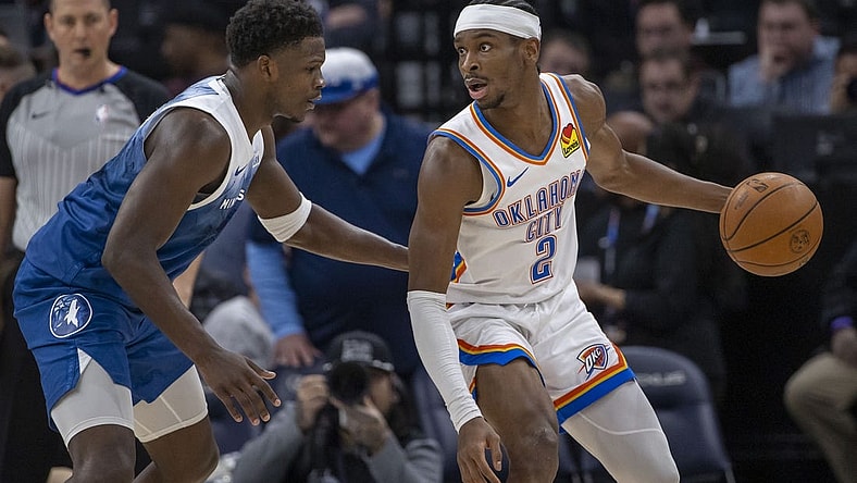 Jan 20, 2024; Minneapolis, Minnesota, USA; Oklahoma City Thunder guard Shai Gilgeous-Alexander (2) looks to pass the ball as Minnesota Timberwolves guard Anthony Edwards (5) plays defense in the second half at Target Center. Mandatory Credit: Jesse Johnson-USA TODAY Sports