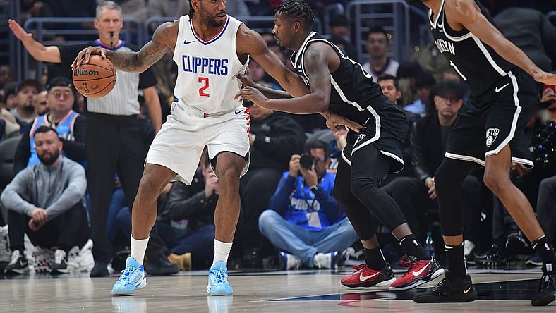 Jan 21, 2024; Los Angeles, California, USA; Los Angeles Clippers forward Kawhi Leonard (2) controls the ball against Brooklyn Nets forward Dorian Finney-Smith (28) and forward Mikal Bridges (1) during the first half at Crypto.com Arena. Mandatory Credit: Gary A. Vasquez-USA TODAY Sports