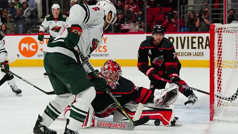 Jan 21, 2024; Raleigh, North Carolina, USA;  Carolina Hurricanes goaltender Antti Raanta (32) stops the scoring attempt by Minnesota Wild defenseman Dakota Mermis (6) during the second period at PNC Arena. Mandatory Credit: James Guillory-USA TODAY Sports