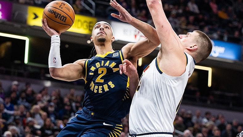 Jan 23, 2024; Indianapolis, Indiana, USA; Indiana Pacers guard Andrew Nembhard (2) shoots the ball while Denver Nuggets center Nikola Jokic (15) defends in the first half at Gainbridge Fieldhouse. Mandatory Credit: Trevor Ruszkowski-USA TODAY Sports