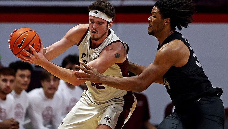 Jan 23, 2024; Blacksburg, Virginia, USA; Boston College Eagles forward Quinten Post (12) handles the ball against Virginia Tech Hokies forward Mylyjael Poteat (34) during the second half at Cassell Coliseum. Mandatory Credit: Peter Casey-USA TODAY Sports