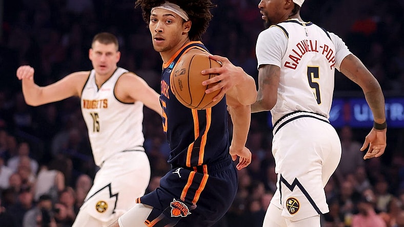 Jan 25, 2024; New York, New York, USA; New York Knicks center Jericho Sims (45) controls the ball against Denver Nuggets center Nikola Jokic (15) and guard Kentavious Caldwell-Pope (5) during the first quarter at Madison Square Garden. Mandatory Credit: Brad Penner-USA TODAY Sports