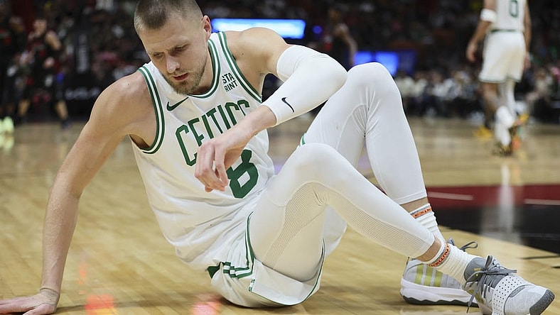 Jan 25, 2024; Miami, Florida, USA; Boston Celtics center Kristaps Porzingis (8) reacts on the floor after a play against the Miami Heat during the third quarter at Kaseya Center. Mandatory Credit: Sam Navarro-USA TODAY Sports