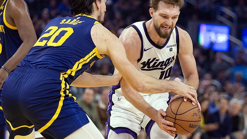 Jan 25, 2024; San Francisco, California, USA; Golden State Warriors center Dario Saric (20) tries to steal the ball from Sacramento Kings forward Domantas Sabonis (10) during the first quarter at Chase Center. Mandatory Credit: D. Ross Cameron-USA TODAY Sports