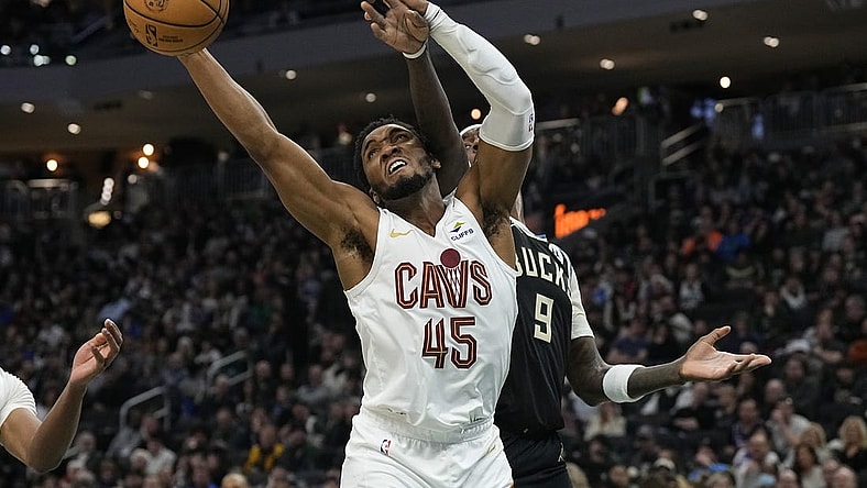 Jan 26, 2024; Milwaukee, Wisconsin, USA;  Cleveland Cavaliers guard Donovan Mitchell (45) reaches for a rebound in front of Milwaukee Bucks forward Bobby Portis (9) during the second quarter at Fiserv Forum. Mandatory Credit: Jeff Hanisch-USA TODAY Sports