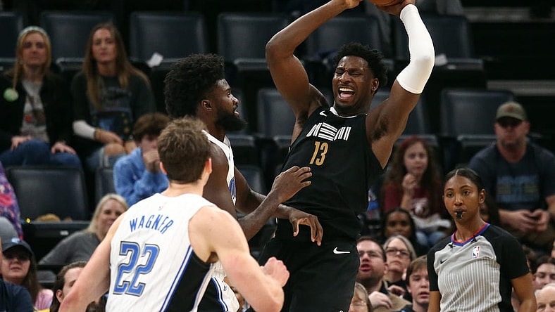 Jan 26, 2024; Memphis, Tennessee, USA; Memphis Grizzlies forward-center Jaren Jackson Jr. (13) collects a rebound over Orlando Magic forward Jonathan Isaac (1) during the first half at FedExForum. Mandatory Credit: Petre Thomas-USA TODAY Sports