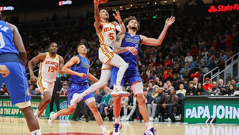 Jan 26, 2024; Atlanta, Georgia, USA; Atlanta Hawks guard Dejounte Murray (5) shoots past Dallas Mavericks center Dereck Lively II (2) in the second half at State Farm Arena. Mandatory Credit: Brett Davis-USA TODAY Sports