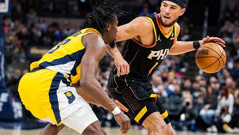 Jan 26, 2024; Indianapolis, Indiana, USA; Phoenix Suns guard Devin Booker (1) dribbles the ball while Indiana Pacers forward Aaron Nesmith (23) defends in the second half at Gainbridge Fieldhouse. Mandatory Credit: Trevor Ruszkowski-USA TODAY Sports