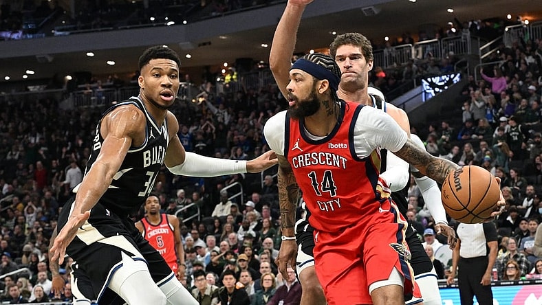 Jan 27, 2024; Milwaukee, Wisconsin, USA; New Orleans Pelicans forward Brandon Ingram (14) dribbles against Milwaukee Bucks forward Giannis Antetokounmpo (34) and Milwaukee Bucks center Brook Lopez (11) in the first half at Fiserv Forum. Mandatory Credit: Michael McLoone-USA TODAY Sports