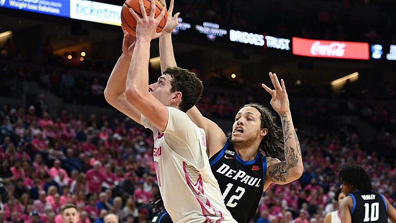 Jan 27, 2024; Omaha, Nebraska, USA; Creighton Bluejays center Ryan Kalkbrenner (11) scores against DePaul Blue Demons forward Mac Etienne (12) in the second half at CHI Health Center Omaha. Mandatory Credit: Steven Branscombe-USA TODAY Sports