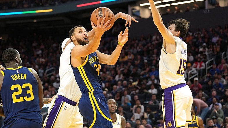 Jan 27, 2024; San Francisco, California, USA; Golden State Warriors guard Stephen Curry (center) shoots against Los Angeles Lakers forward Anthony Davis (obscured) and guard Austin Reaves (15) during the third quarter at Chase Center. Mandatory Credit: Darren Yamashita-USA TODAY Sports