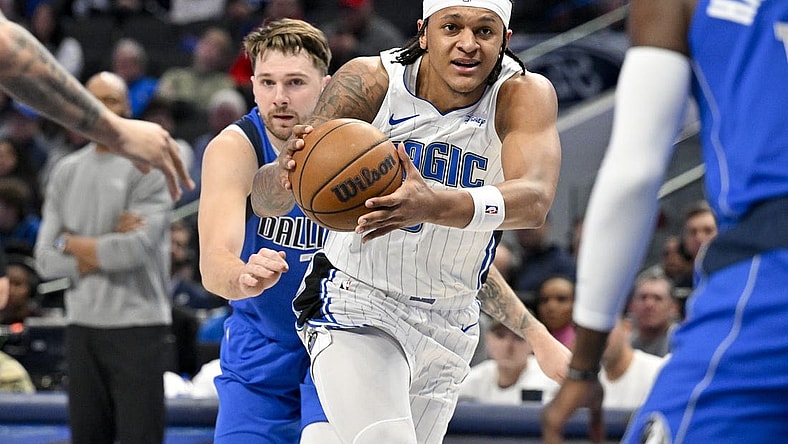 Jan 29, 2024; Dallas, Texas, USA; Orlando Magic forward Paolo Banchero (5) drives to the basket past Dallas Mavericks guard Luka Doncic (77) during the first quarter at the American Airlines Center. Mandatory Credit: Jerome Miron-USA TODAY Sports