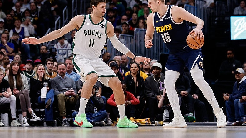 Jan 29, 2024; Denver, Colorado, USA; Denver Nuggets center Nikola Jokic (15) controls the ball as Milwaukee Bucks center Brook Lopez (11) guards in the second quarter at Ball Arena. Mandatory Credit: Isaiah J. Downing-USA TODAY Sports
