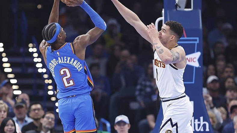 Jan 31, 2024; Oklahoma City, Oklahoma, USA; Oklahoma City Thunder guard Shai Gilgeous-Alexander (2) shoots as Denver Nuggets forward Michael Porter Jr. (1) defends during the first quarter at Paycom Center. Mandatory Credit: Alonzo Adams-USA TODAY Sports