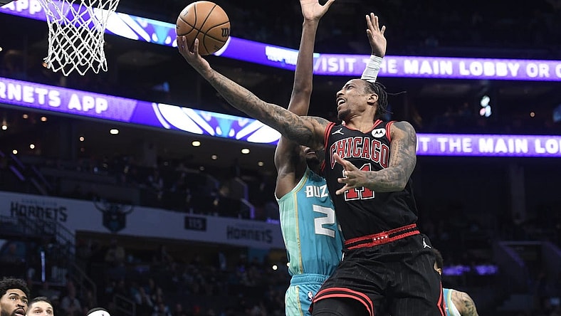 Jan 31, 2024; Charlotte, North Carolina, USA;  Chicago Bulls guard DeMar DeRozan (11) drives in for a lay-up past Charlotte Hornets forward guard Brandon Miller (24) during the second half at the Spectrum Center. Mandatory Credit: Sam Sharpe-USA TODAY Sports