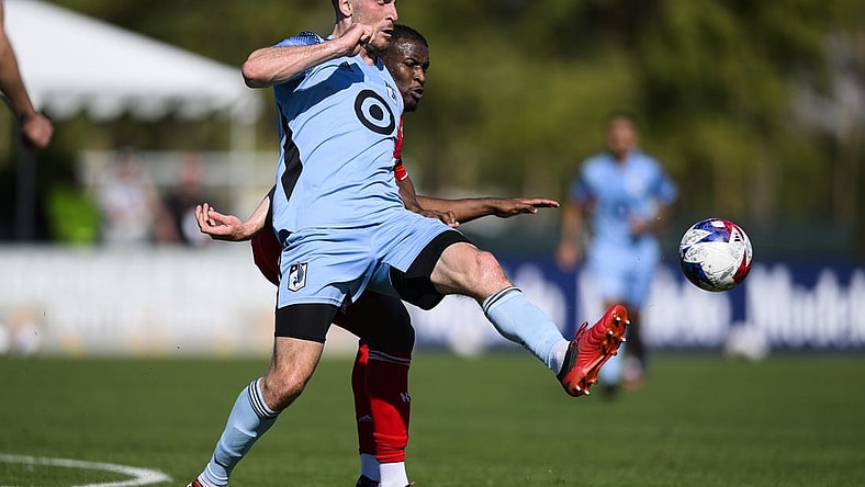 Feb 11, 2023; Indio, CA, USA; Minnesota United Brent Kallman (14) kicks the ball away from New York Red Bulls Elias Manoel (11) at Empire Polo Club. Mandatory Credit: Kelvin Kuo-USA TODAY Sports