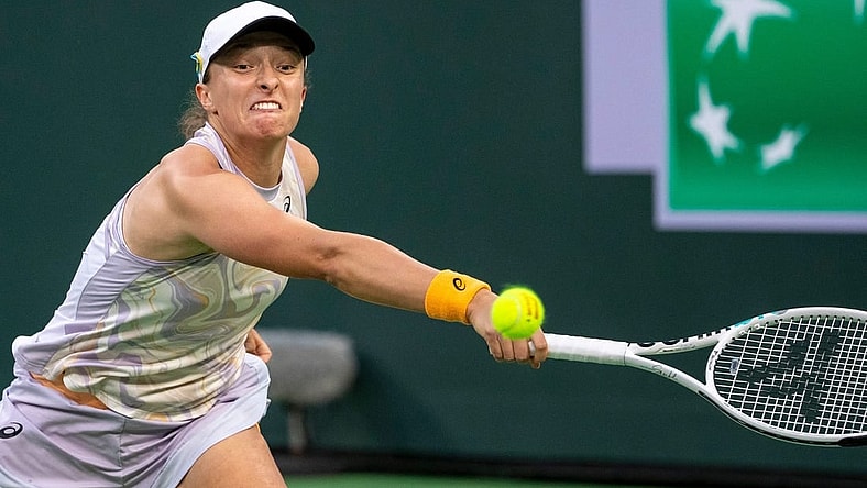 Iga Swiatek of Poland reaches out to hit to Elena Rybakina of Kazakhstan during their semifinal match at the BNP Paribas Open at the Indian Wells Tennis Garden in Indian Wells, Calif., Friday, March 17, 2023.