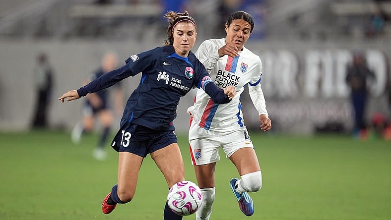 Nov 5, 2023; San Diego, California, USA;  San Diego Wave FC forward Alex Morgan (13) and OL Reign defender Alana Cook (4) battle for the ball in the second half at Snapdragon Stadium. Mandatory Credit: Ray Acevedo-USA TODAY Sports