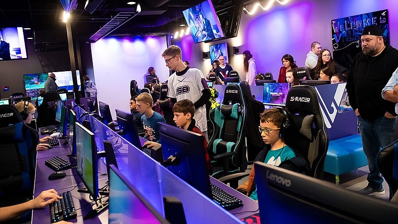 Jonathan Walker (standing, center) helps a group of young gamers during a pre-grand opening event at Valhallan Esports Training on Thursday, Nov. 30, 2023, in Camp Hill. Walker is the Apex Legends coach at Valhallan.