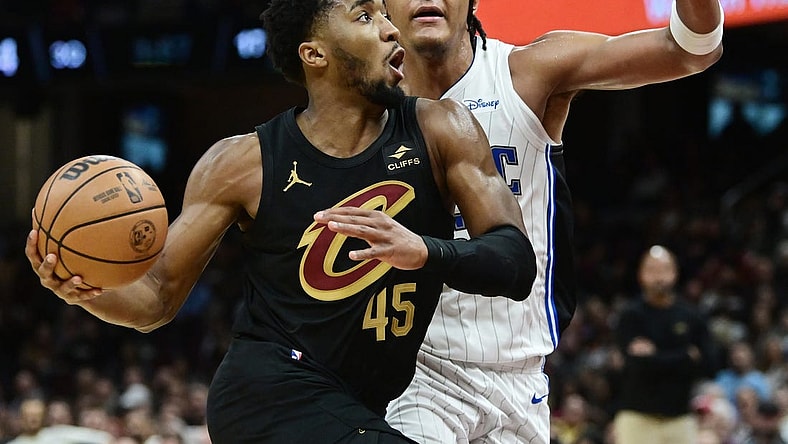 Dec 6, 2023; Cleveland, Ohio, USA; Cleveland Cavaliers guard Donovan Mitchell (45) drives to the basket against Orlando Magic forward Paolo Banchero (5) during the second half at Rocket Mortgage FieldHouse. Mandatory Credit: Ken Blaze-USA TODAY Sports