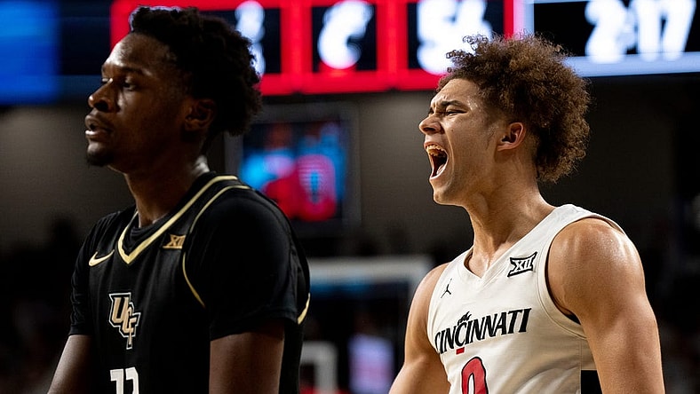 Cincinnati Bearcats guard Dan Skillings Jr. (0) reacts to hitting a 3-point basket over UCF Knights forward Marchelus Avery (13) to put Cincinnati Bearcats up by 5 points with under 3 minutes to play in the second half of the NCAA basketball game between Cincinnati Bearcats and UCF Knights at Fifth Third Arena in Cincinnati on Saturday, Jan. 27, 2024.