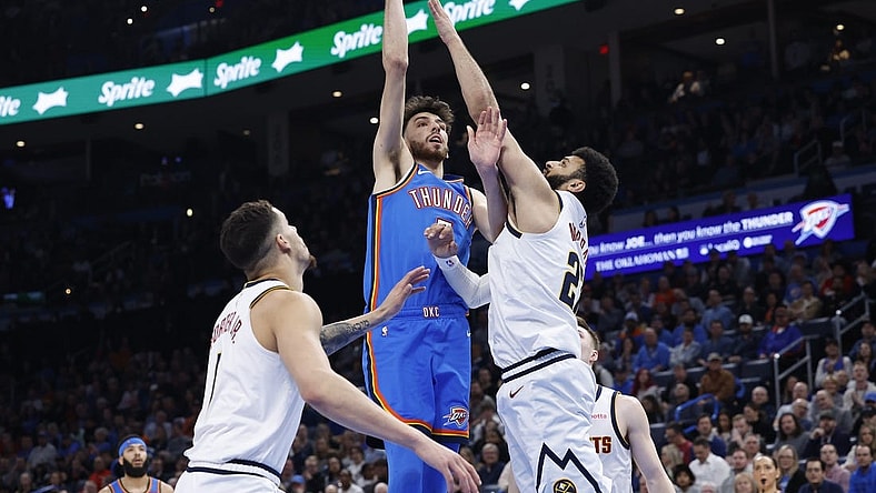 Jan 31, 2024; Oklahoma City, Oklahoma, USA; Oklahoma City Thunder forward Chet Holmgren (7) shoots as Denver Nuggets guard Jamal Murray (27) defends during the second half at Paycom Center. Mandatory Credit: Alonzo Adams-USA TODAY Sports