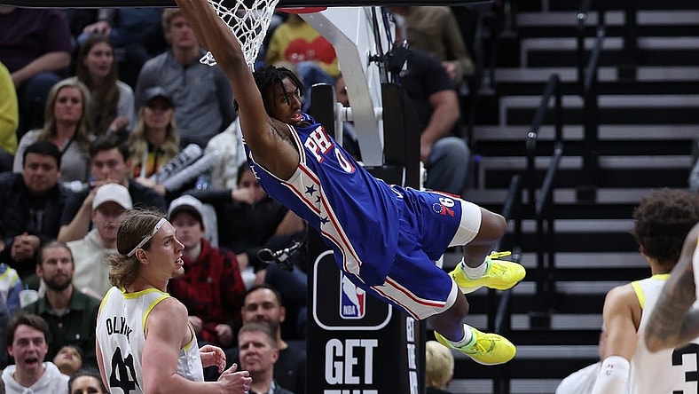 Feb 1, 2024; Salt Lake City, Utah, USA; Philadelphia 76ers guard Tyrese Maxey (0) hangs on the rim after a dunk against the Utah Jazz during the fourth quarter at Delta Center. Mandatory Credit: Rob Gray-USA TODAY Sports