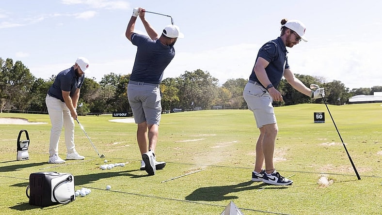Feb 2, 2024; Playa del Carmen, Quintana Roo, MEX; Jon Rahm of Team Legion XIII, center, hits on the practice range with teammates Tyrrell Hatton, left, and Kieran Vincent before the first round of the LIV Golf Mayakoba tournament at El Chamaleon Golf Course. Mandatory Credit: Erich Schlegel-USA TODAY Sports