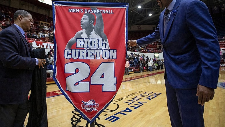 Detroit Mercy athletic director Robert C. Vowels, Jr., left, and Earl Cureton, unveil the No. 24 jersey retirement during the ceremony at Calihan Hall in Detroit, Thursday, Jan. 23, 2020.