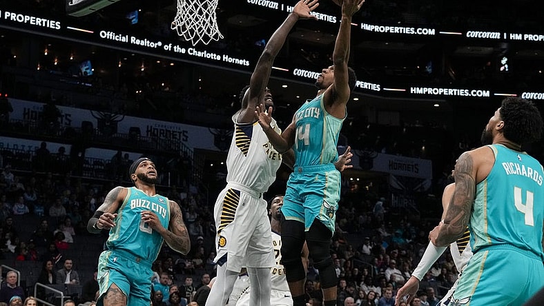 Feb 4, 2024; Charlotte, North Carolina, USA; Charlotte Hornets guard Ish Smith (14) gets a fast break basket defended by Indiana Pacers forward Aaron Nesmith (23) during the first quarter at Spectrum Center. Mandatory Credit: Jim Dedmon-USA TODAY Sports