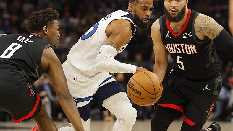 Feb 4, 2024; Minneapolis, Minnesota, USA; Minnesota Timberwolves guard Mike Conley (10) drives between Houston Rockets forward Jae'Sean Tate (8) and guard Fred VanVleet (5) in the first quarter at Target Center. Mandatory Credit: Bruce Kluckhohn-USA TODAY Sports