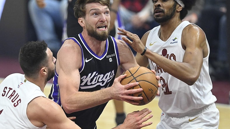 Feb 5, 2024; Cleveland, Ohio, USA; Sacramento Kings forward Domantas Sabonis (10) drives between Cleveland Cavaliers guard Max Strus (1) and center Jarrett Allen (31) in the first quarter at Rocket Mortgage FieldHouse. Mandatory Credit: David Richard-USA TODAY Sports