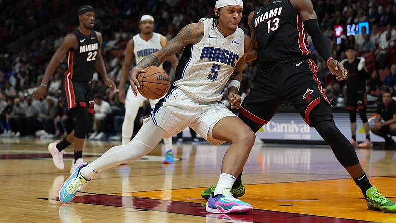 Feb 6, 2024; Miami, Florida, USA;  Orlando Magic forward Paolo Banchero (5) drives to the basket as Miami Heat center Bam Adebayo (13) defends during the second half at Kaseya Center. Mandatory Credit: Jim Rassol-USA TODAY Sports