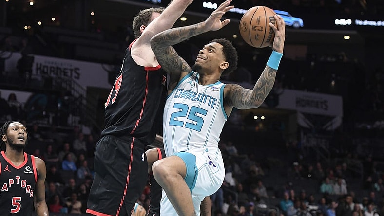 Feb 7, 2024; Charlotte, North Carolina, USA; Charlotte Hornets forward center P.J. Washington Jr. (25) drives in past Toronto Raptors center Jakob Poeltl (19) during the first half at the Spectrum Center. Mandatory Credit: Sam Sharpe-USA TODAY Sports