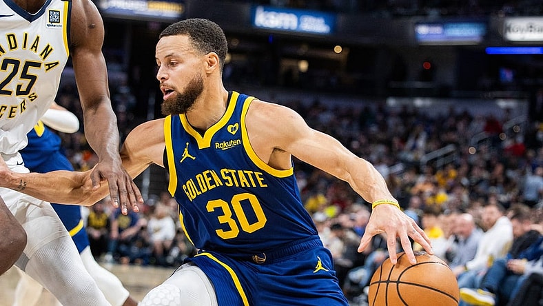 Feb 8, 2024; Indianapolis, Indiana, USA; Golden State Warriors guard Stephen Curry (30) dribbles the ball while Indiana Pacers forward Jalen Smith (25) defends in the first half at Gainbridge Fieldhouse. Mandatory Credit: Trevor Ruszkowski-USA TODAY Sports